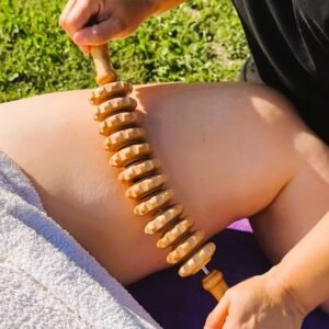 Visuel en gros plan sur une séance de maderothérapie au niveau de l'interieur de la cuisse avec un rouleau à picots en bois.