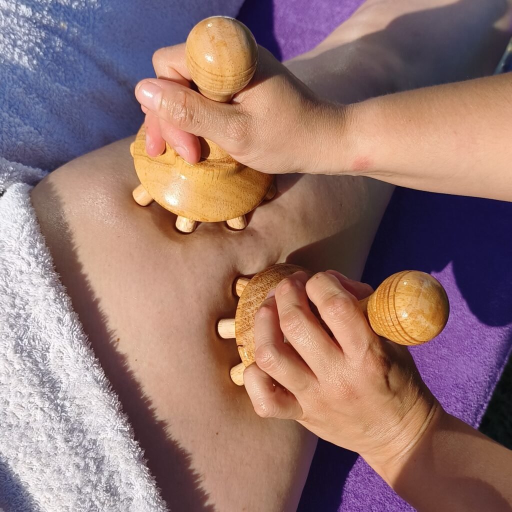 Visuel en gros plan sur une séance de maderothérapie au niveau du fessier avec des outils en bois appeler champignons.